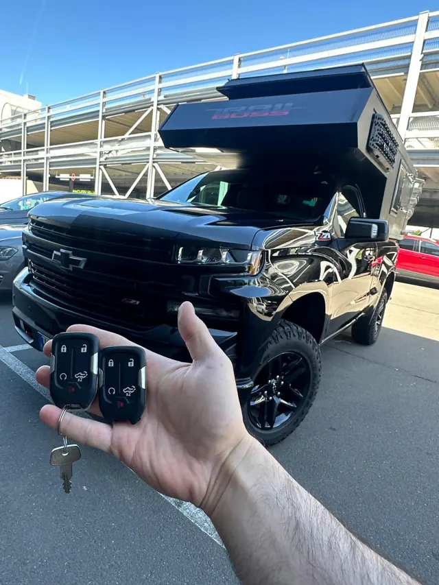 Zwei Smart Keys vor einem schwarzen Chevrolet Silverado mit Wohnkabine