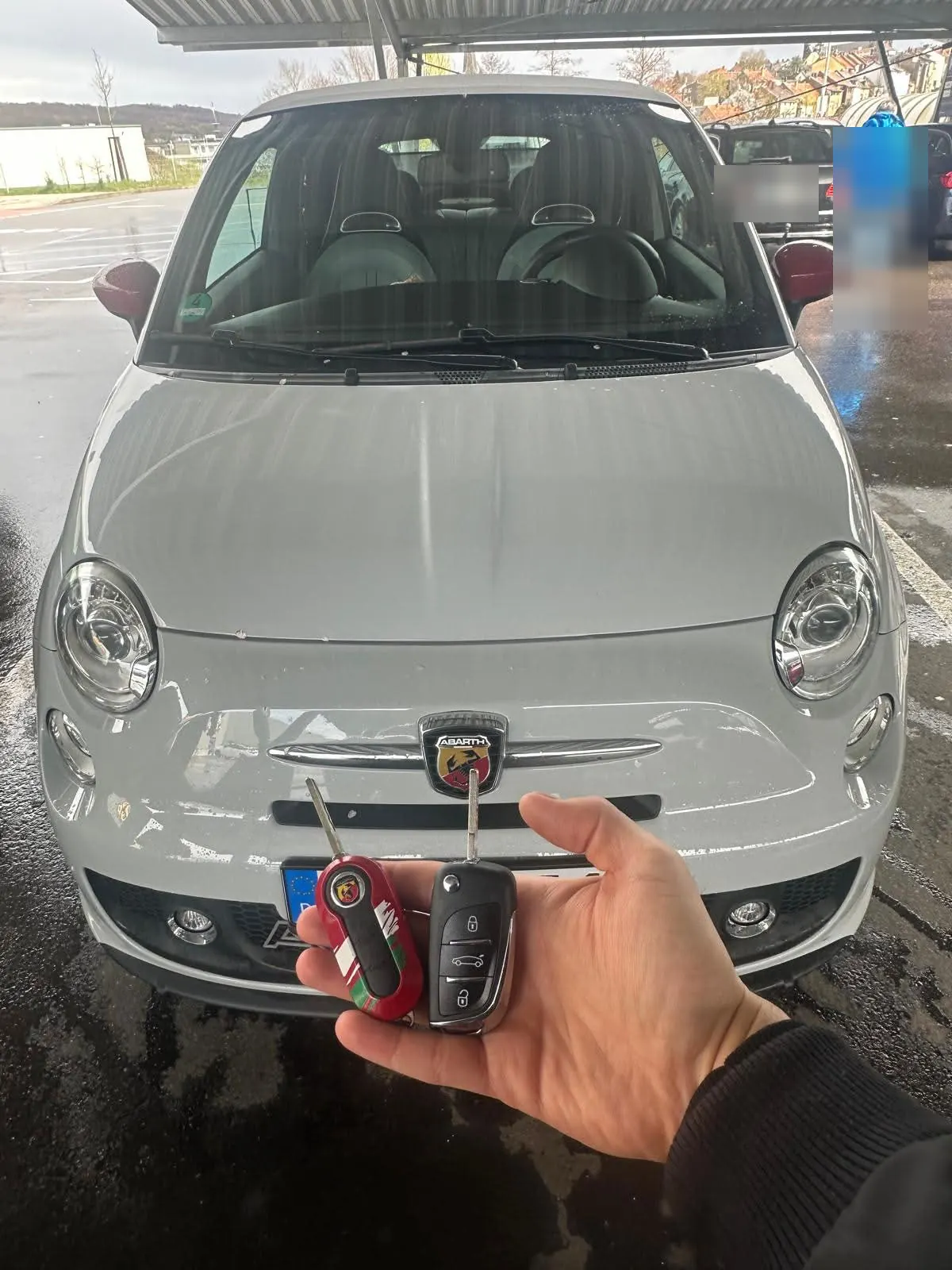 Neuer Klappschlüssel vor einem weißen Fiat 500 Abarth