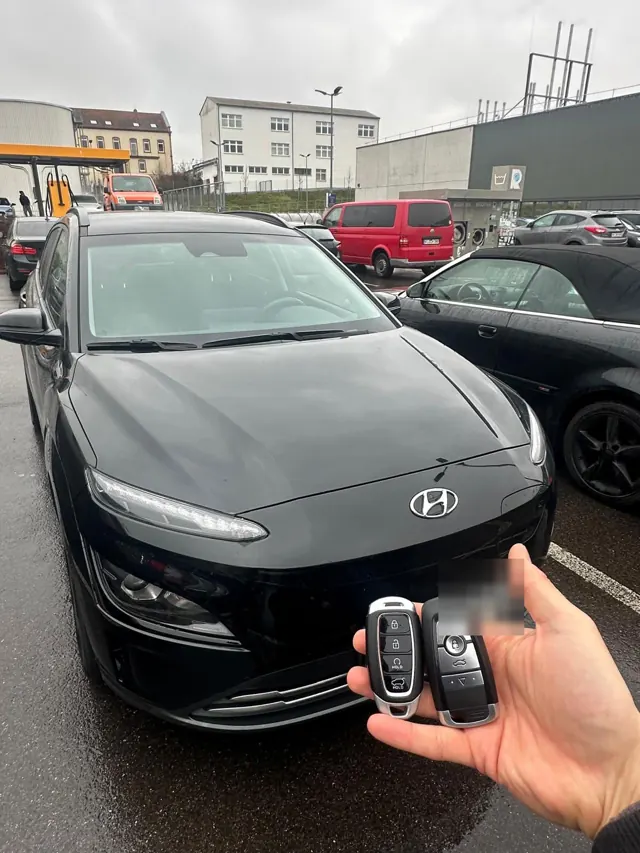 Zwei Smart Keys vor einem schwarzen Hyundai Kona