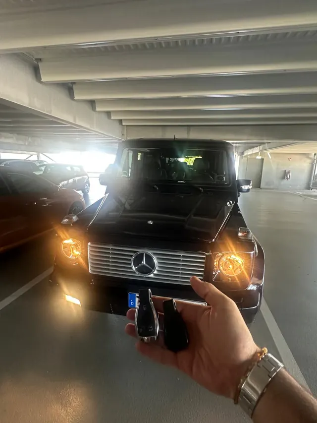 Neuer Mercedes-Schlüssel vor einer Mercedes G-Klasse im Parkhaus