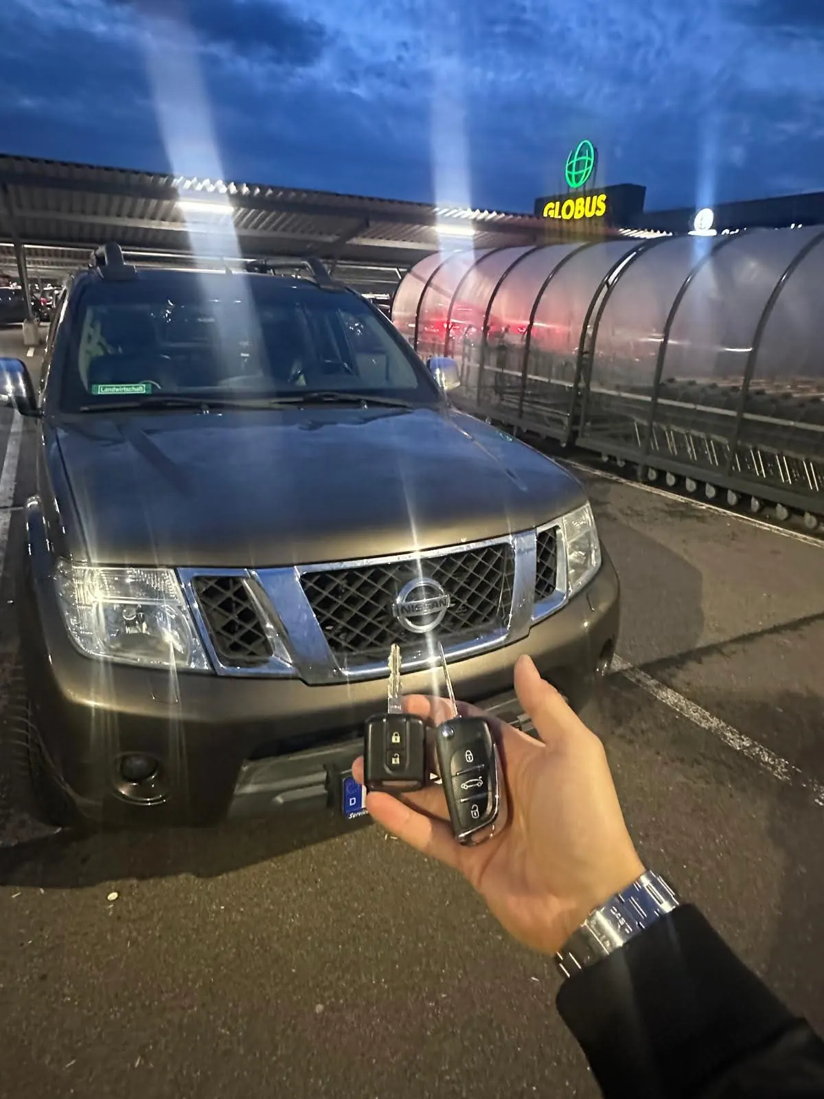 Zwei Klappschlüssel vor einem Nissan am Globus