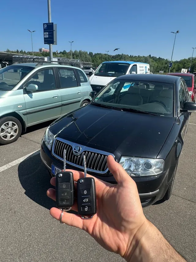 Zwei neue Klappschlüssel vor einem schwarzen Škoda Superb