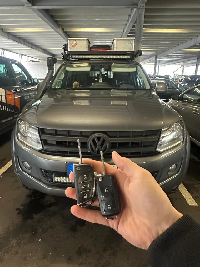 Zwei neue Klappschlüssel vor einem VW Amarok im Parkhaus